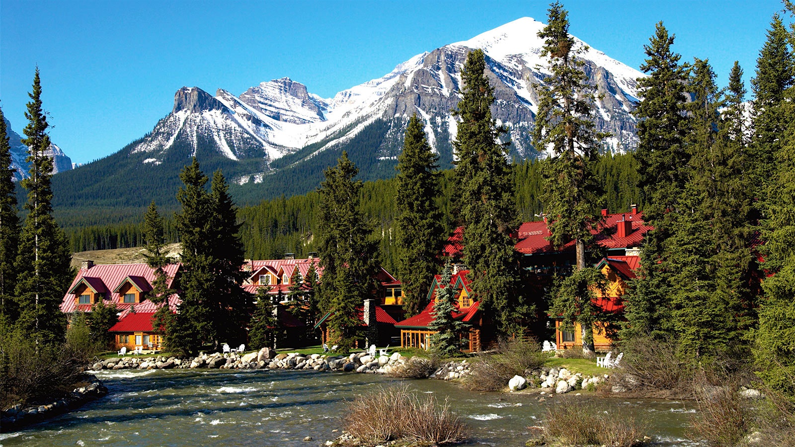The exterior of the Post Hotel in Lake Louise, Alberta, Canada, with Banff mountain in the background